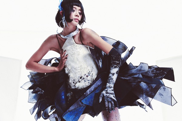 Shot from below, Look B fills the frame: the beaded bodice and its mirror fragments above dark shard panels that swing past the edge of the picture.