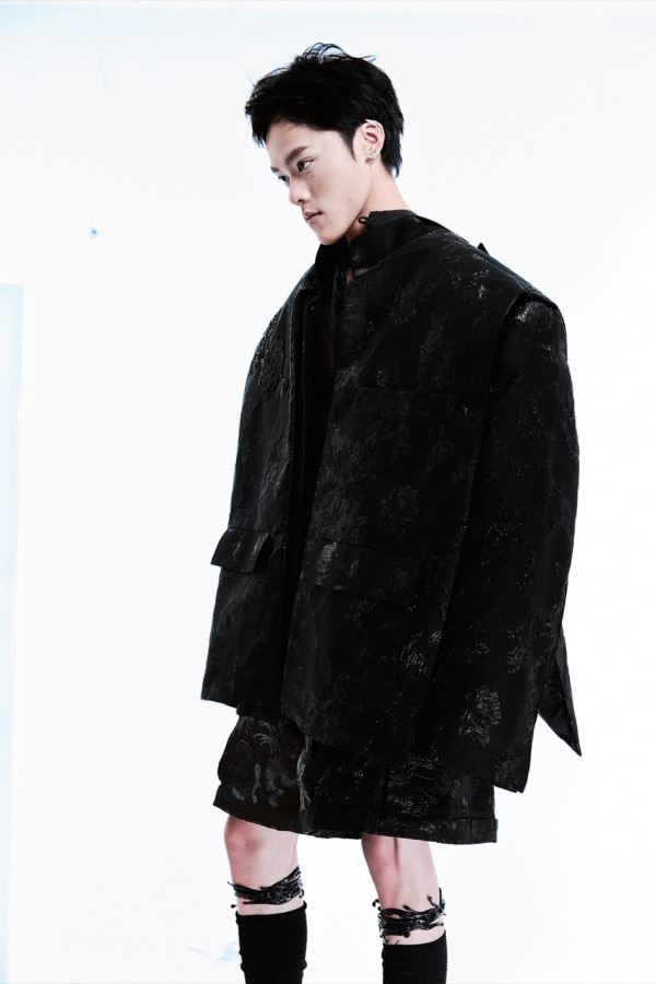 In three-quarter profile, patch pockets sit low on Look C's jacquard jacket, its floral pattern catching side light above the tailored shorts beneath.