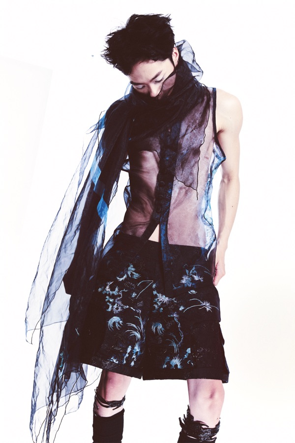 Bent forward at the waist, Look C's button placket runs down the sheer layer above turquoise floral embroidery worked densely across the shorts.
