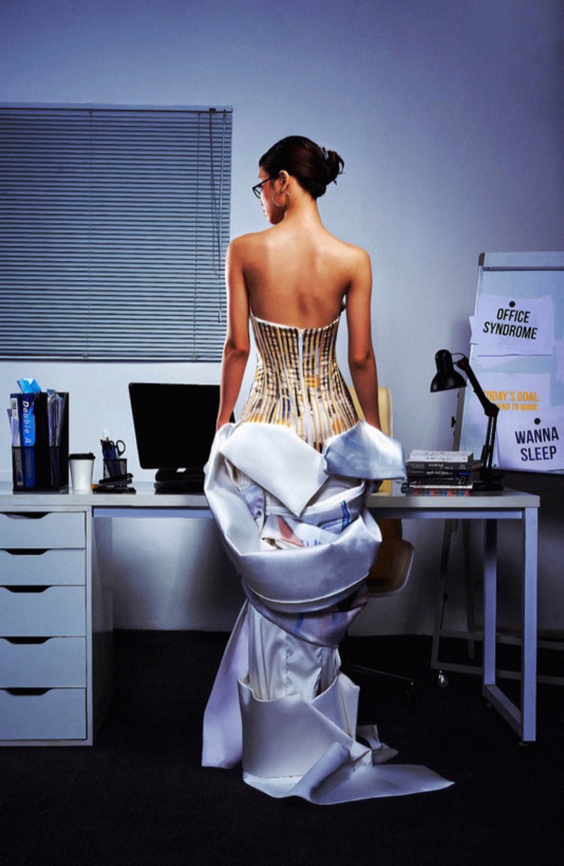 Back view of the look at an office desk beside a monitor reading OFFICE SYNDROME