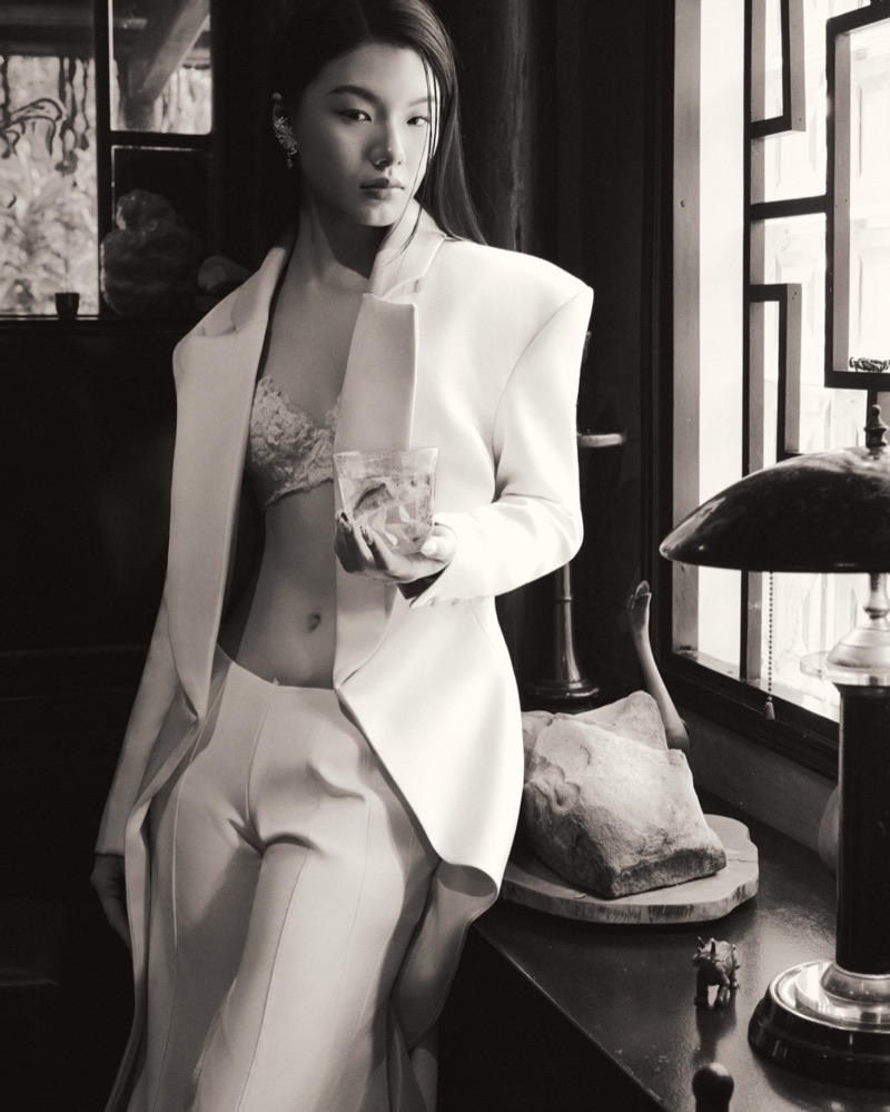 Black-and-white frame by the window with a glass in hand, tailoring detail up close